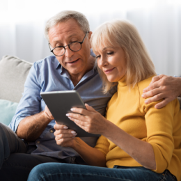 Elderly man and woman looking at their retirement account on their tablet