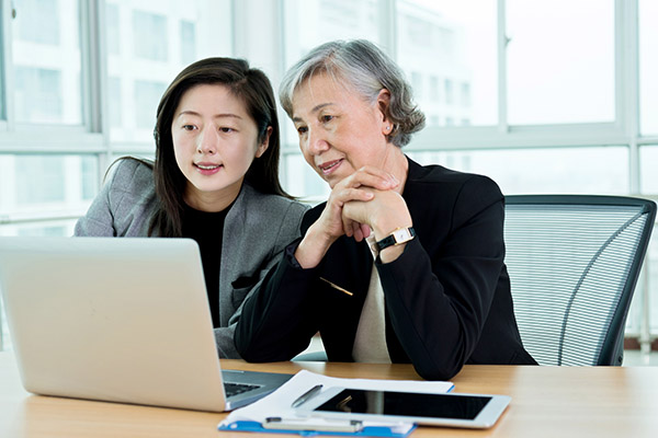 two ladies sitting at computer